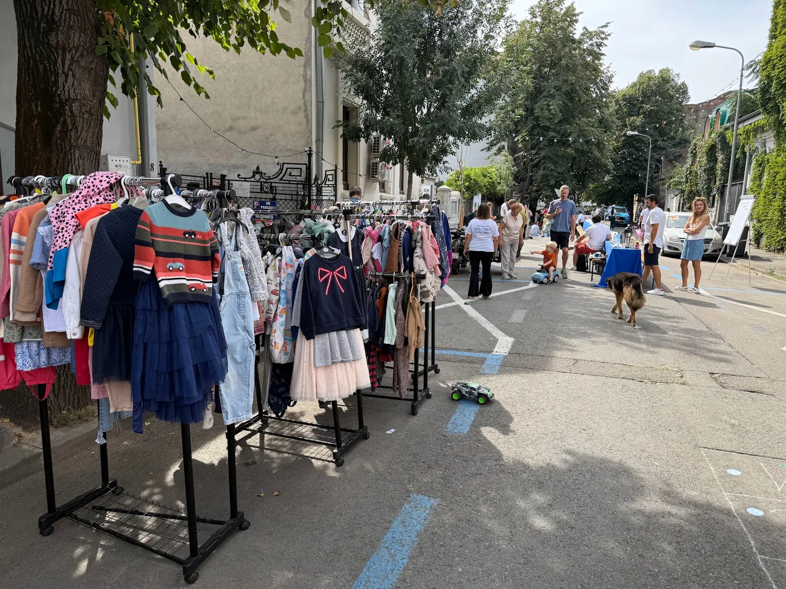 Standere cu haine pentru copii la un eveniment Kinderbazar în cartier