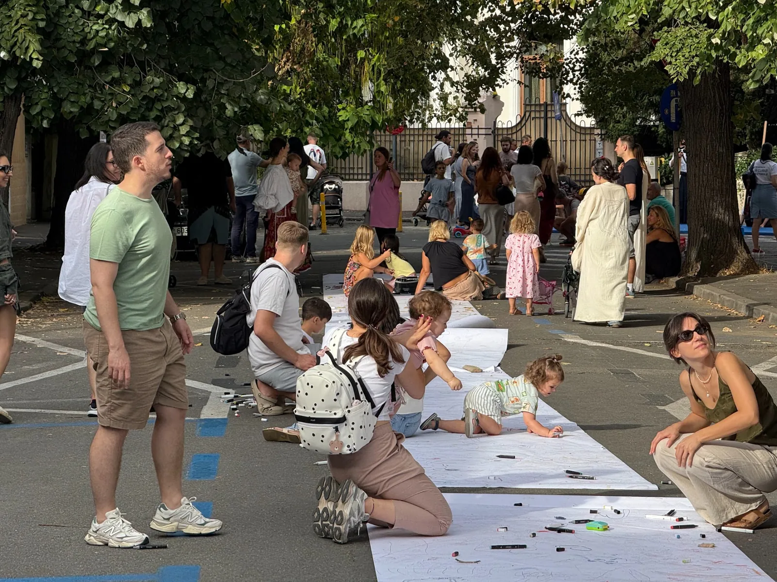 Părinți și copii desenând împreună pe stradă la Kinderbazar