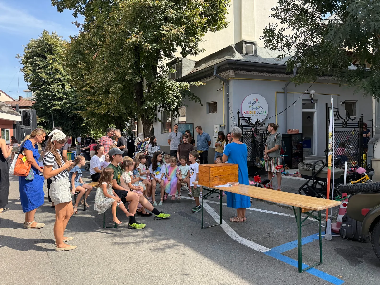 Moment de comunitate cu părinți și copii în fața magazinului Kinderbazar