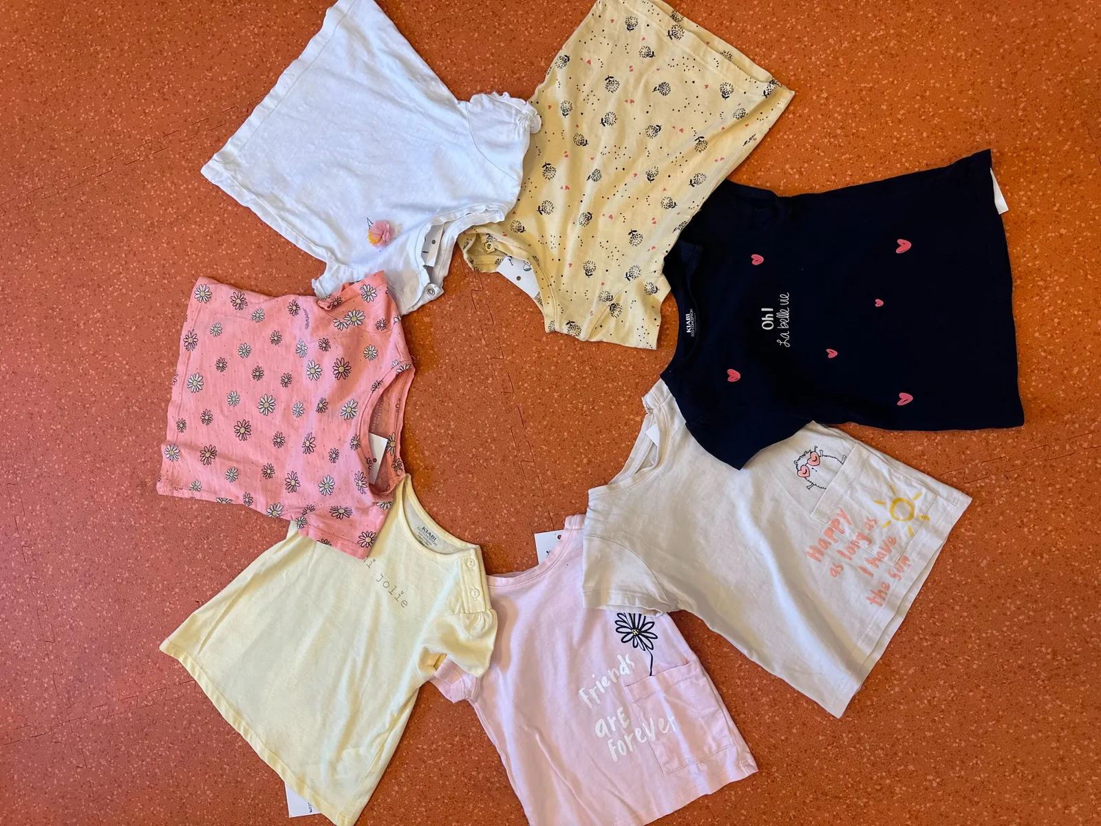 Selecție de tricouri pentru copii în culori pastel, haine second-hand la Kinderbazar